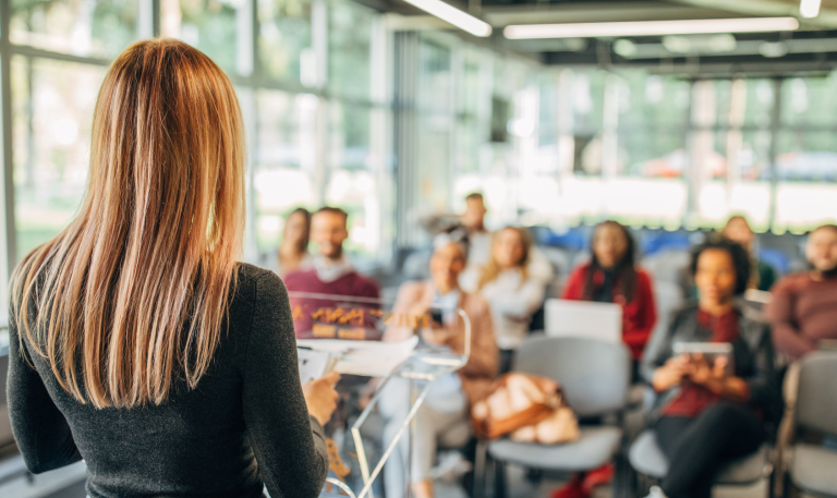 Woman presenting to a crowd of people